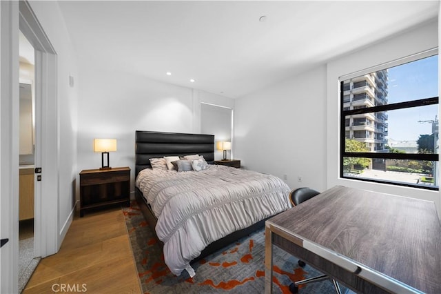 bedroom featuring ensuite bathroom and hardwood / wood-style flooring