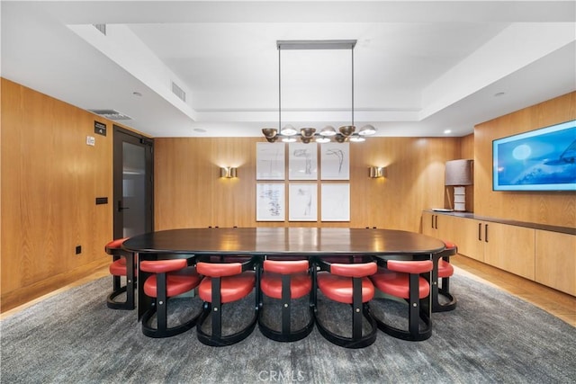 game room with wooden walls and a tray ceiling