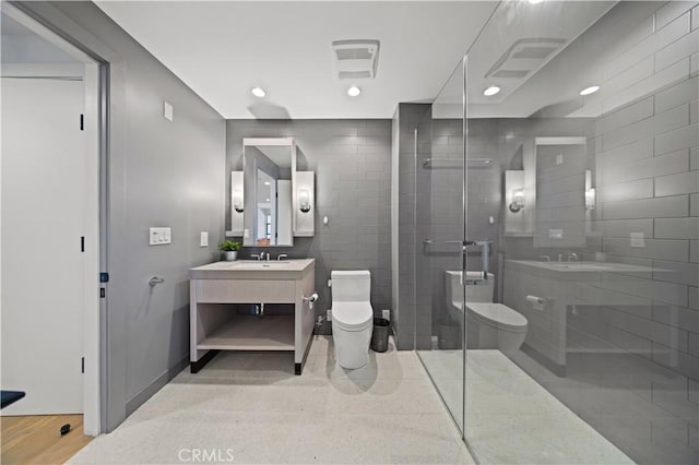 bathroom featuring hardwood / wood-style flooring, a shower with door, vanity, and toilet