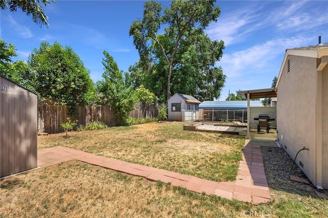 view of yard featuring a storage shed and a patio