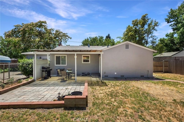 back of property featuring a patio and a lawn