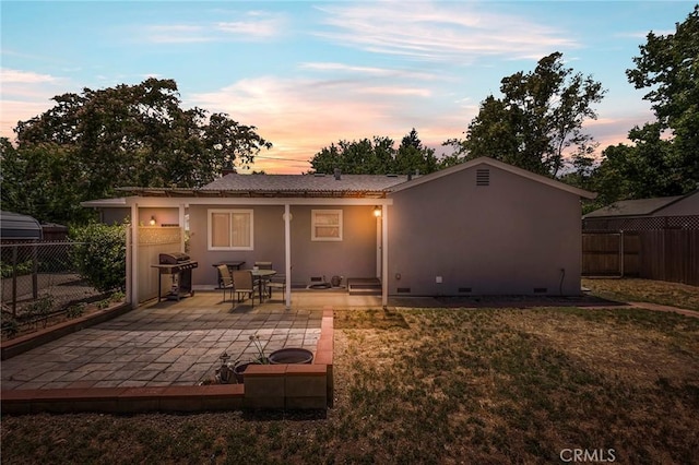 1116 Sheridan Ave, Chico, CA 95926 - back of house at dusk featuring a yard, a patio, a fenced backyard, and stucco siding