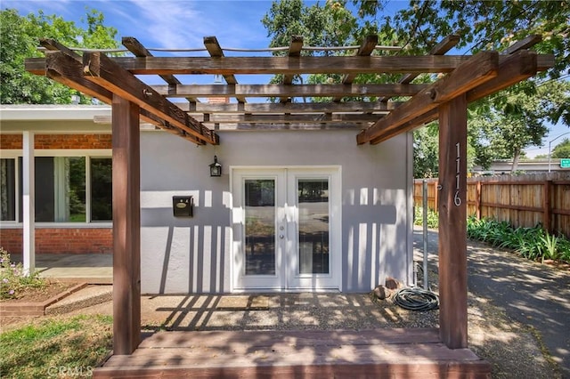 property entrance with french doors, a pergola, and a patio area