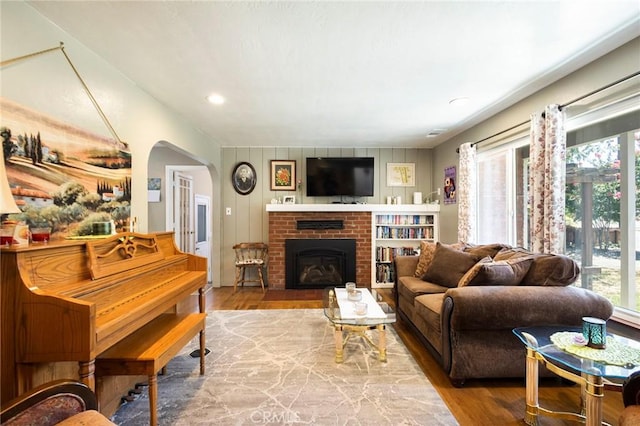 living room with hardwood / wood-style flooring and a brick fireplace