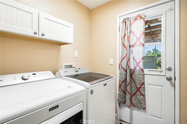 laundry room featuring cabinets and washing machine and clothes dryer