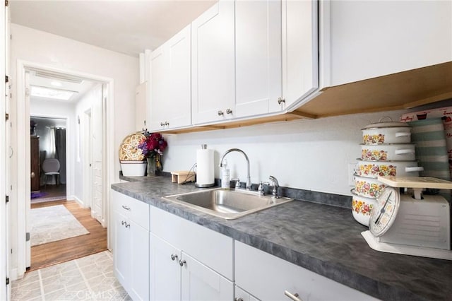 1116 Sheridan Ave, Chico, CA 95926 - kitchen featuring light wood-type flooring, a sink, white cabinets, and dark countertops