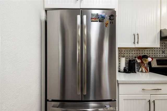 kitchen with tasteful backsplash, appliances with stainless steel finishes, extractor fan, and white cabinets