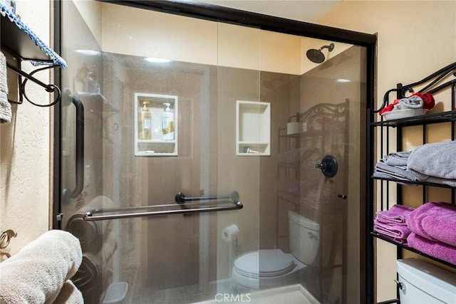 bathroom with an enclosed shower and toilet