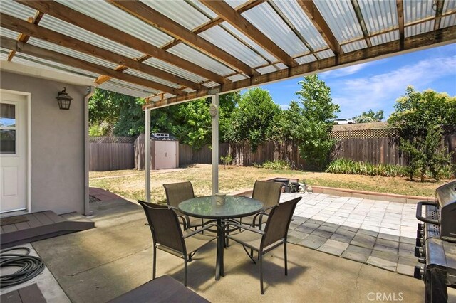 1116 Sheridan Ave, Chico, CA 95926 - view of patio with a fenced backyard, outdoor dining space, a pergola, and a storage shed
