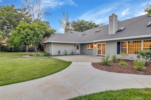 back of property featuring a patio area, french doors, and a yard