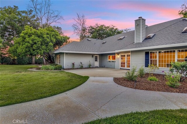 view of front of home with a patio, french doors, and a yard