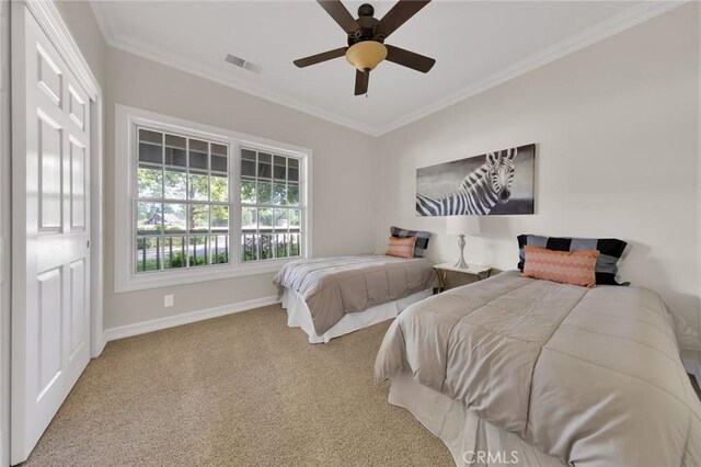 bedroom featuring ceiling fan, ornamental molding, and carpet floors