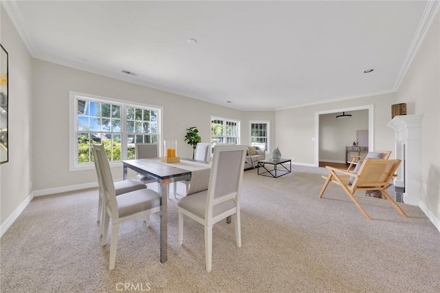 dining room featuring ornamental molding and light carpet