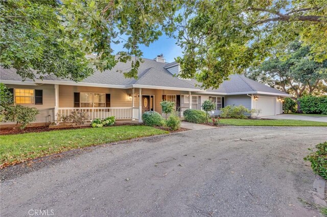 ranch-style house featuring a garage and a porch