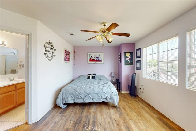 bedroom with ceiling fan, light wood-type flooring, sink, and connected bathroom