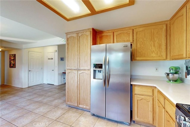 kitchen with stainless steel fridge with ice dispenser, light brown cabinetry, light tile patterned floors, and electric stove