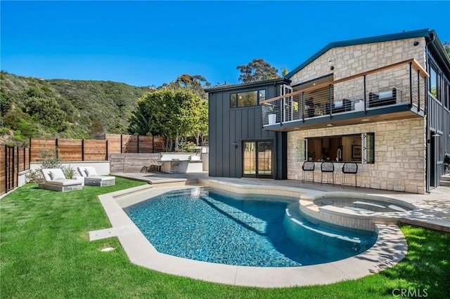 view of pool with an in ground hot tub, an outdoor hangout area, a patio, a mountain view, and a yard