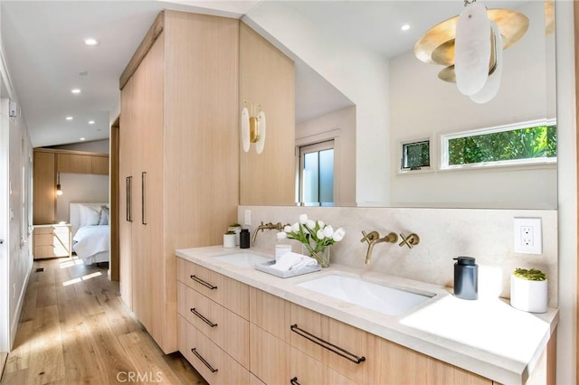 bathroom with backsplash, vanity, and hardwood / wood-style flooring