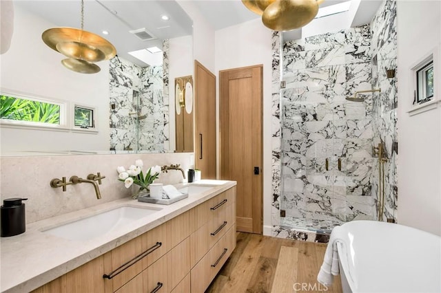 bathroom featuring vanity, hardwood / wood-style floors, and plus walk in shower