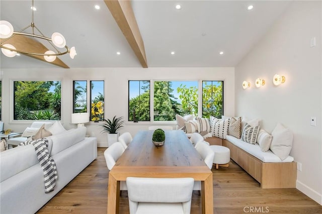 living room with lofted ceiling with beams, light hardwood / wood-style floors, and an inviting chandelier