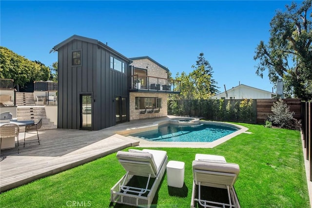 view of pool featuring an in ground hot tub, a yard, and a wooden deck