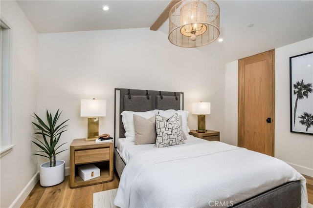 bedroom with ceiling fan, light hardwood / wood-style flooring, and lofted ceiling with beams