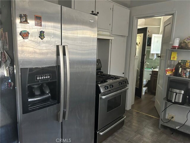 kitchen with stainless steel appliances, white cabinetry, and tasteful backsplash