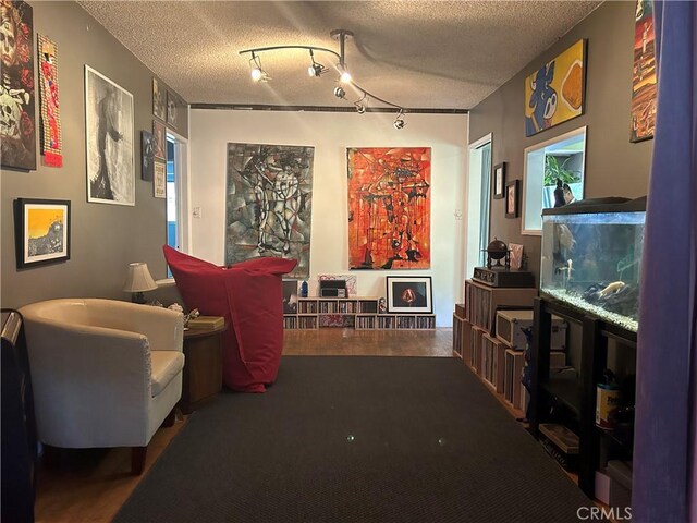 interior space with rail lighting and a textured ceiling