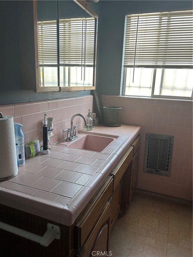 kitchen featuring backsplash, tile counters, and sink