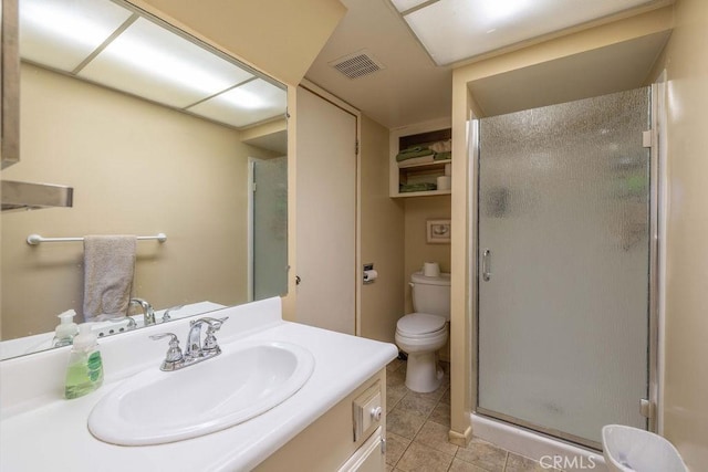 bathroom with tile patterned floors, vanity, toilet, and a shower with shower door