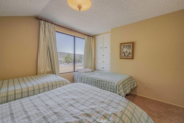 carpeted bedroom with a textured ceiling and lofted ceiling