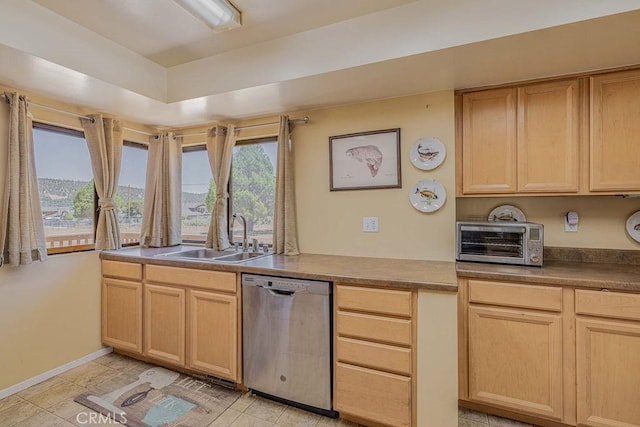 kitchen featuring dishwasher, light brown cabinetry, a wealth of natural light, and sink