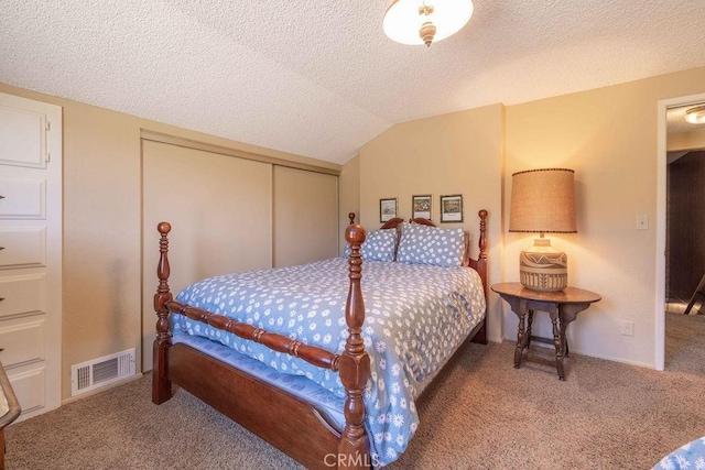 carpeted bedroom featuring a textured ceiling, a closet, and vaulted ceiling