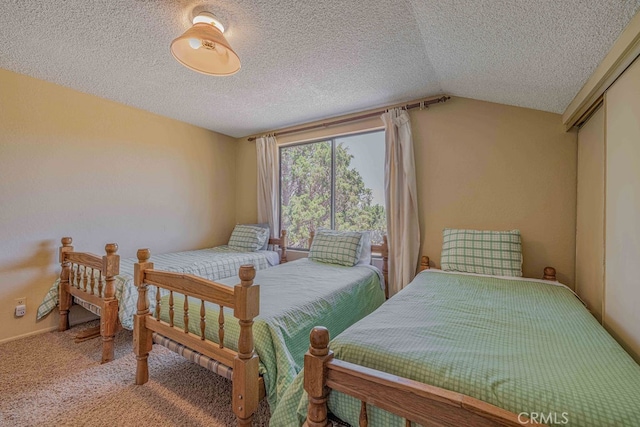 bedroom with carpet flooring, a closet, a textured ceiling, and vaulted ceiling