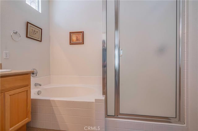 bathroom with vanity and shower with separate bathtub