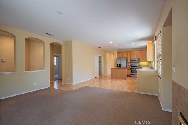 kitchen featuring light brown cabinetry, sink, light carpet, and stainless steel appliances