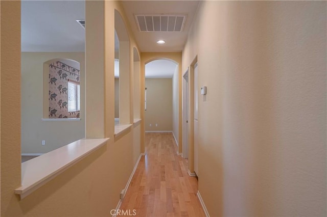 corridor with light hardwood / wood-style floors