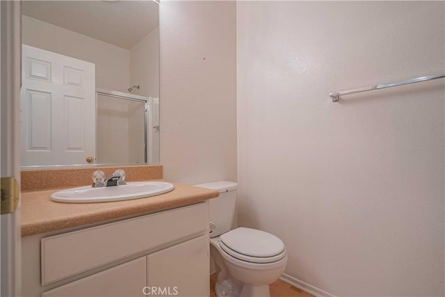 bathroom with vanity, a shower with shower door, and toilet