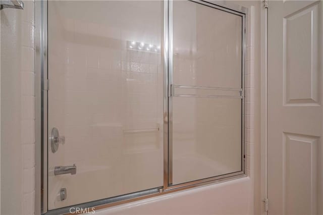 bathroom with combined bath / shower with glass door