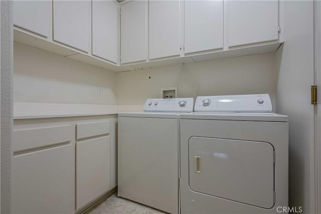 washroom with cabinets and washer and clothes dryer