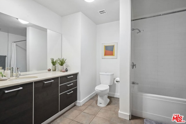 full bathroom with tile patterned floors, tiled shower / bath, vanity, and toilet