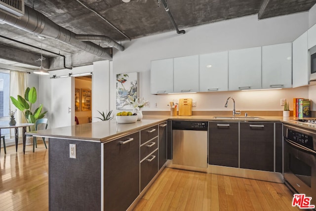 kitchen with white cabinets, dark brown cabinets, light hardwood / wood-style floors, and appliances with stainless steel finishes