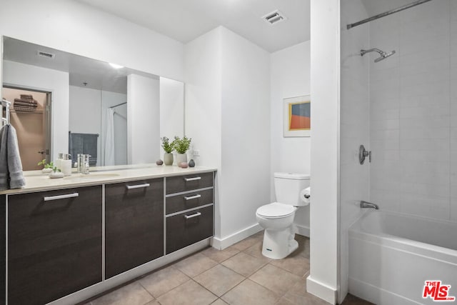 full bathroom featuring tile patterned flooring, vanity, tiled shower / bath combo, and toilet