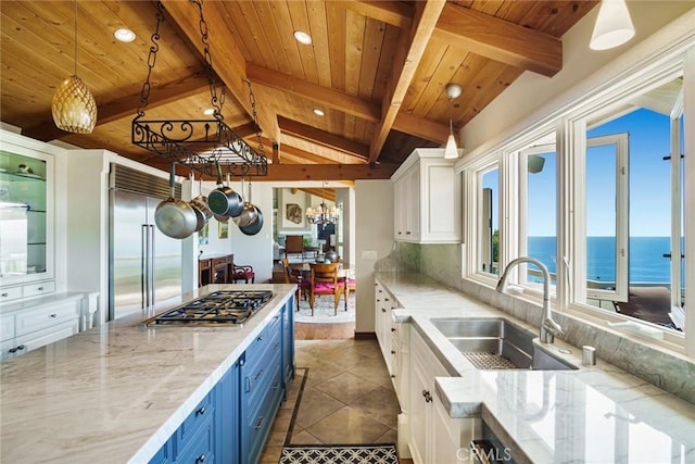 kitchen featuring sink, white cabinets, stainless steel appliances, a water view, and blue cabinetry