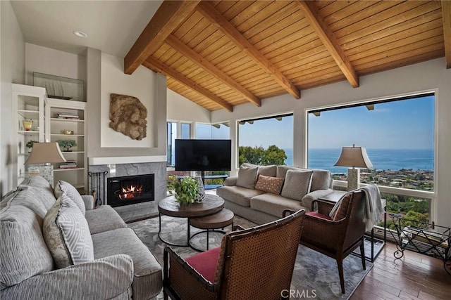 living room featuring a healthy amount of sunlight, vaulted ceiling with beams, dark wood-type flooring, and a high end fireplace