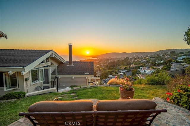 yard at dusk featuring a mountain view and a patio area