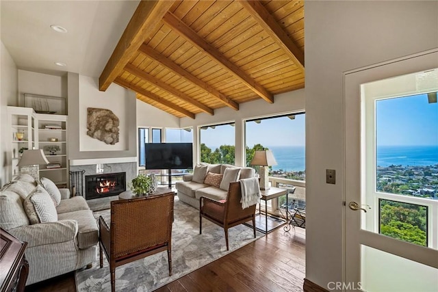 interior space with beam ceiling, wood ceiling, high vaulted ceiling, hardwood / wood-style flooring, and a premium fireplace