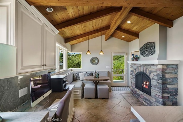 tiled living room with breakfast area, wood ceiling, a fireplace, and lofted ceiling with beams