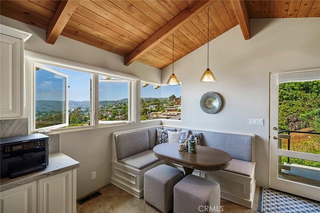 sunroom / solarium with breakfast area, wood ceiling, a healthy amount of sunlight, and vaulted ceiling with beams