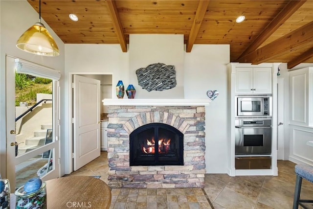 living room with vaulted ceiling with beams, a fireplace, wooden ceiling, and light tile patterned flooring